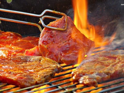 Steaks being cooked on a BBQ grill