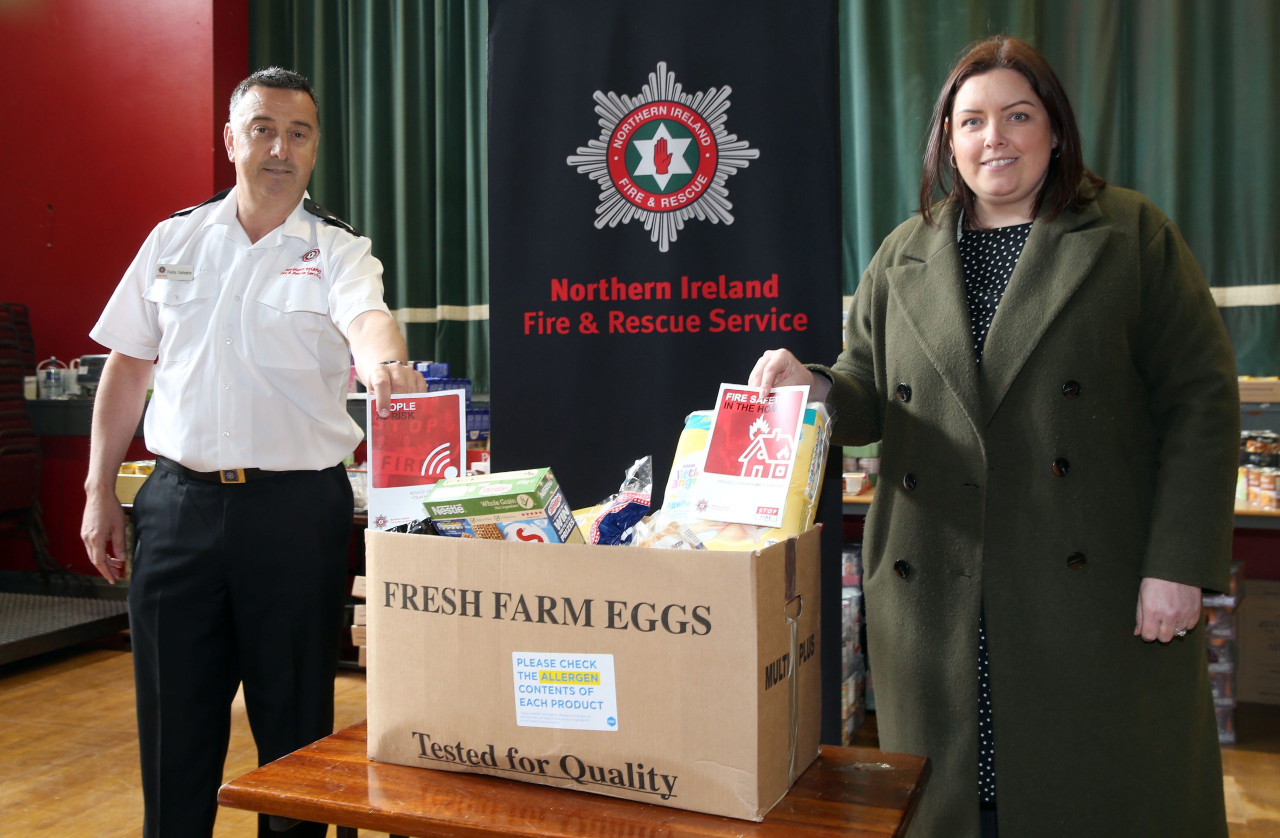Paddy Gallagher & Deirdre Hargey beside food parcel