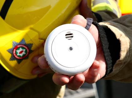 community-safety firefighter holding a smoke alarm